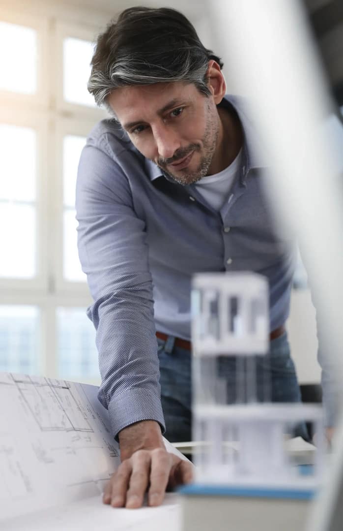 Man in office looking at architectural model